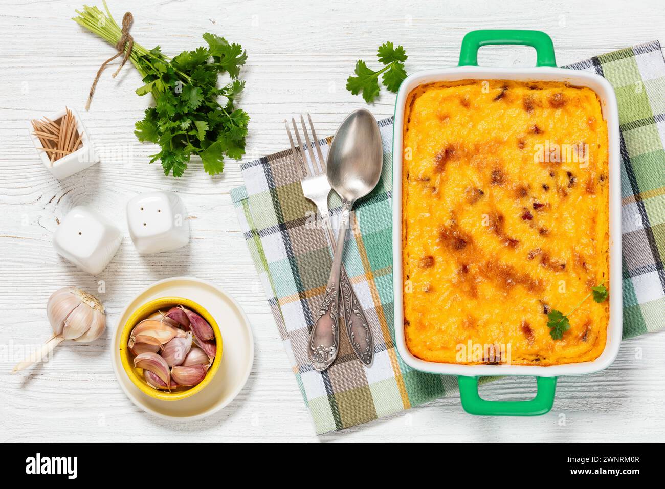 smoked sausage cheese grits casserole in green baking dish on white ...