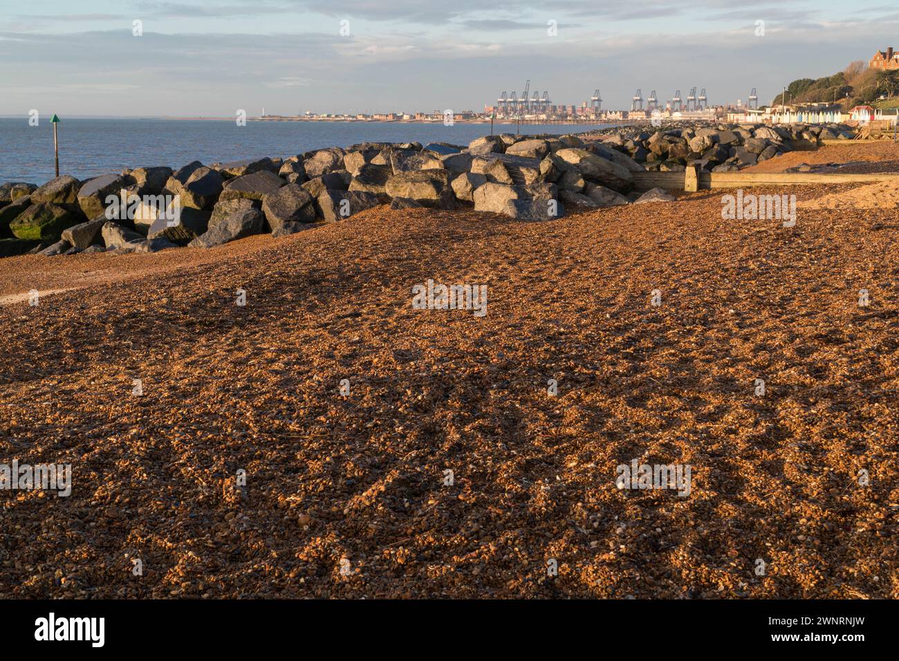 Sunrise over Felixstowe beach and coastal defenses with the Docks in the background Suffolk England UK. February 2024 Stock Photo