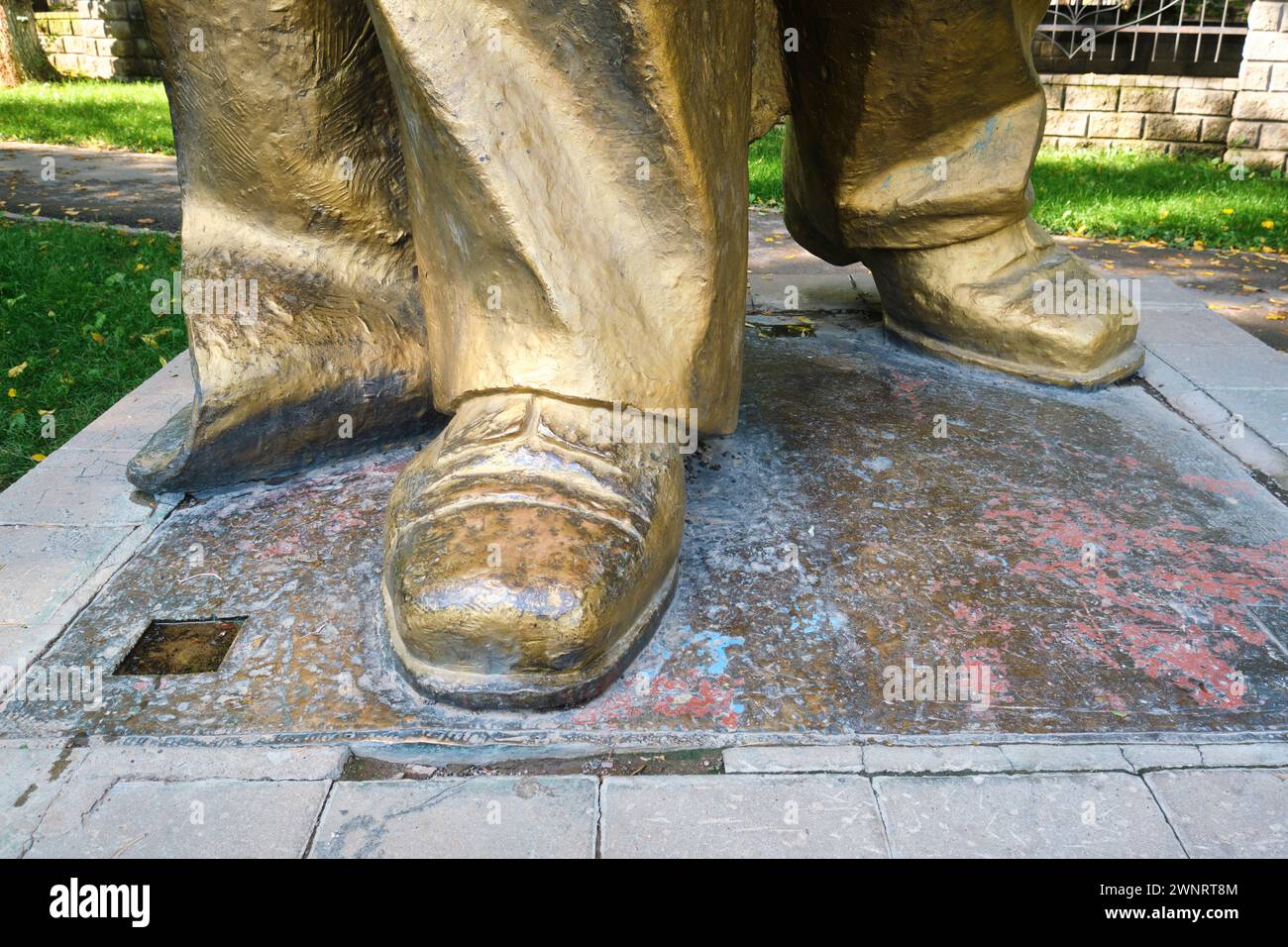 View of the shoes, feet on the large, gold painted statue of Vladimir Lenin. The Muzey Pamyatnikov Sovetskoy Skul'ptury in the Square of Sary-Arka of Stock Photo