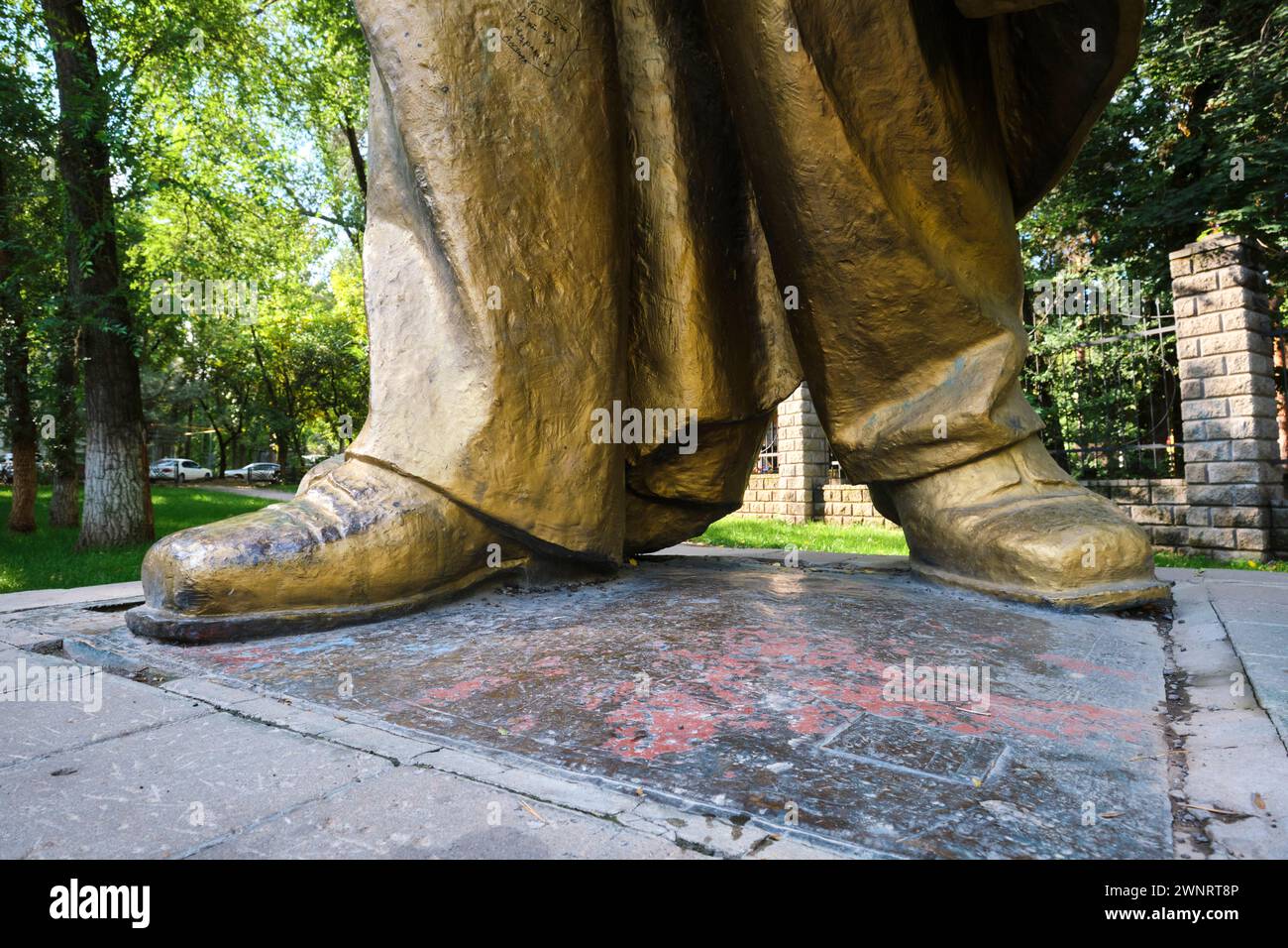 View of the shoes, feet on the large, gold painted statue of Vladimir Lenin. The Muzey Pamyatnikov Sovetskoy Skul'ptury in the Square of Sary-Arka of Stock Photo