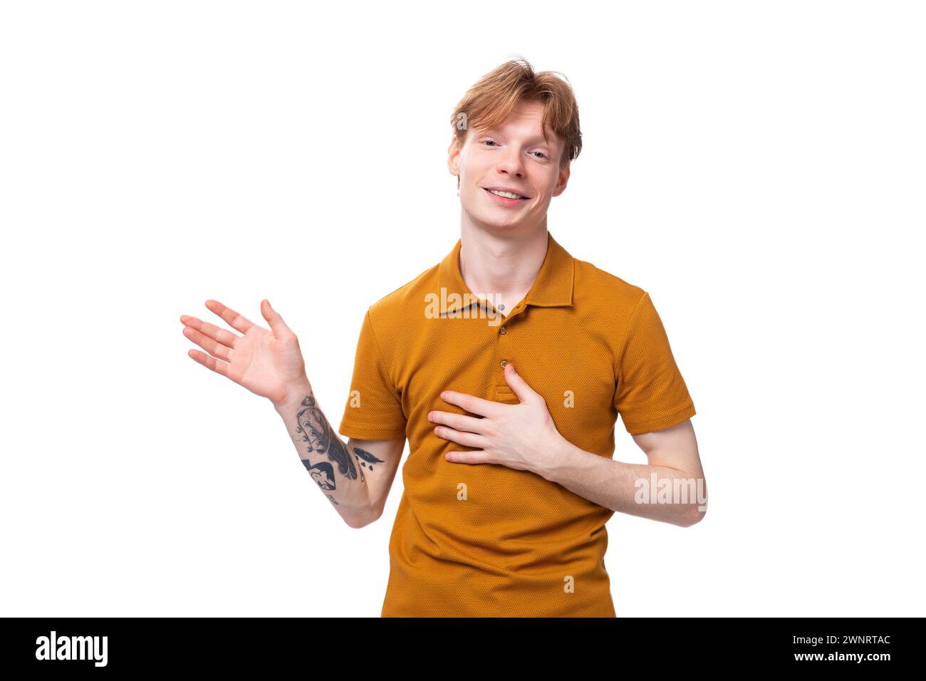 young man with red hair in orange t-shirt shows stop gesture Stock Photo