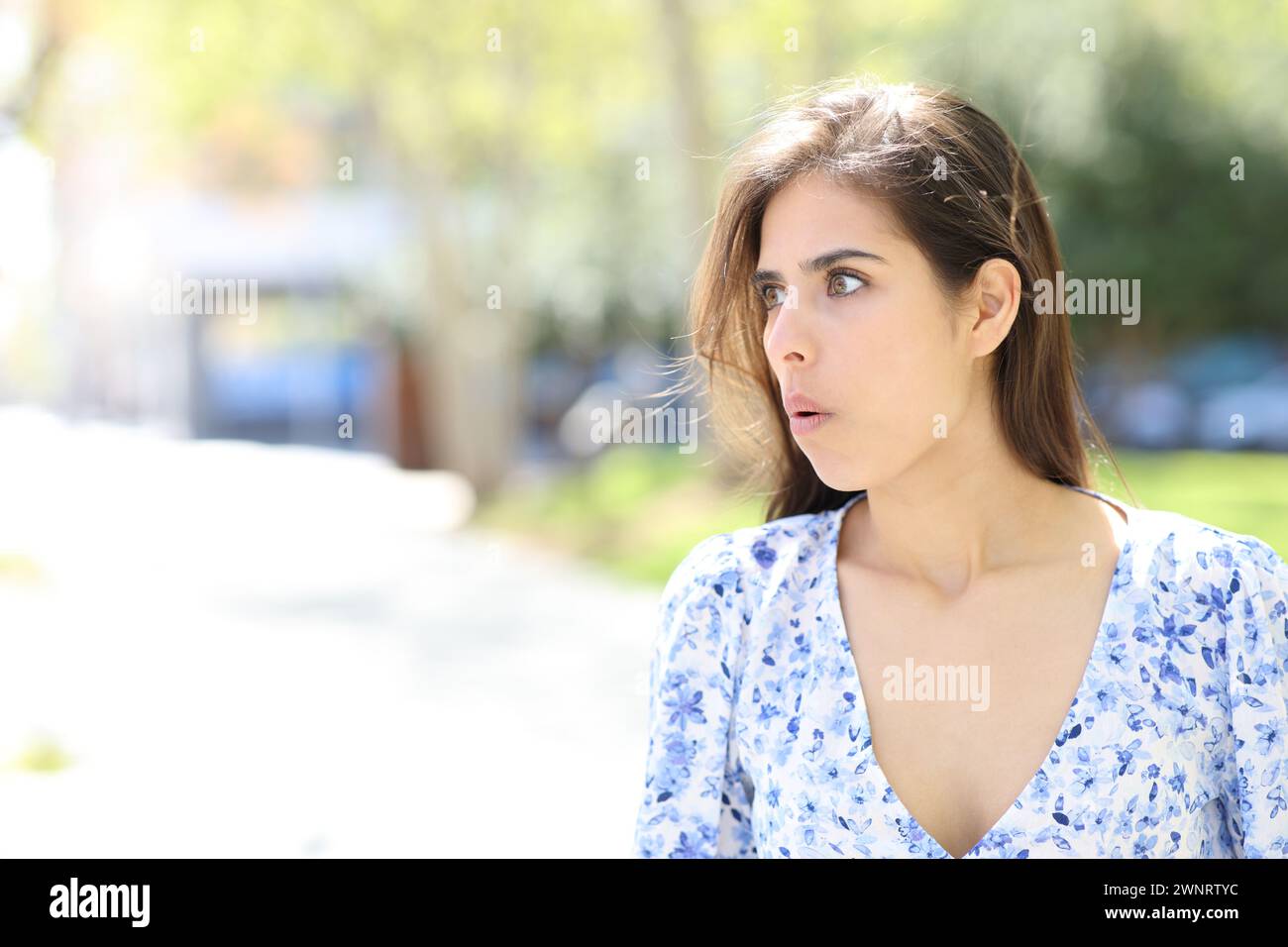 Shocked woman looking at side walking in the street Stock Photo