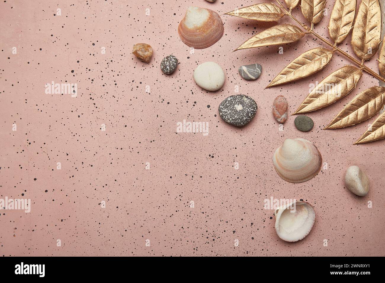 Summer background with golden leaves and seashells on pink sand with copy space. Stock Photo