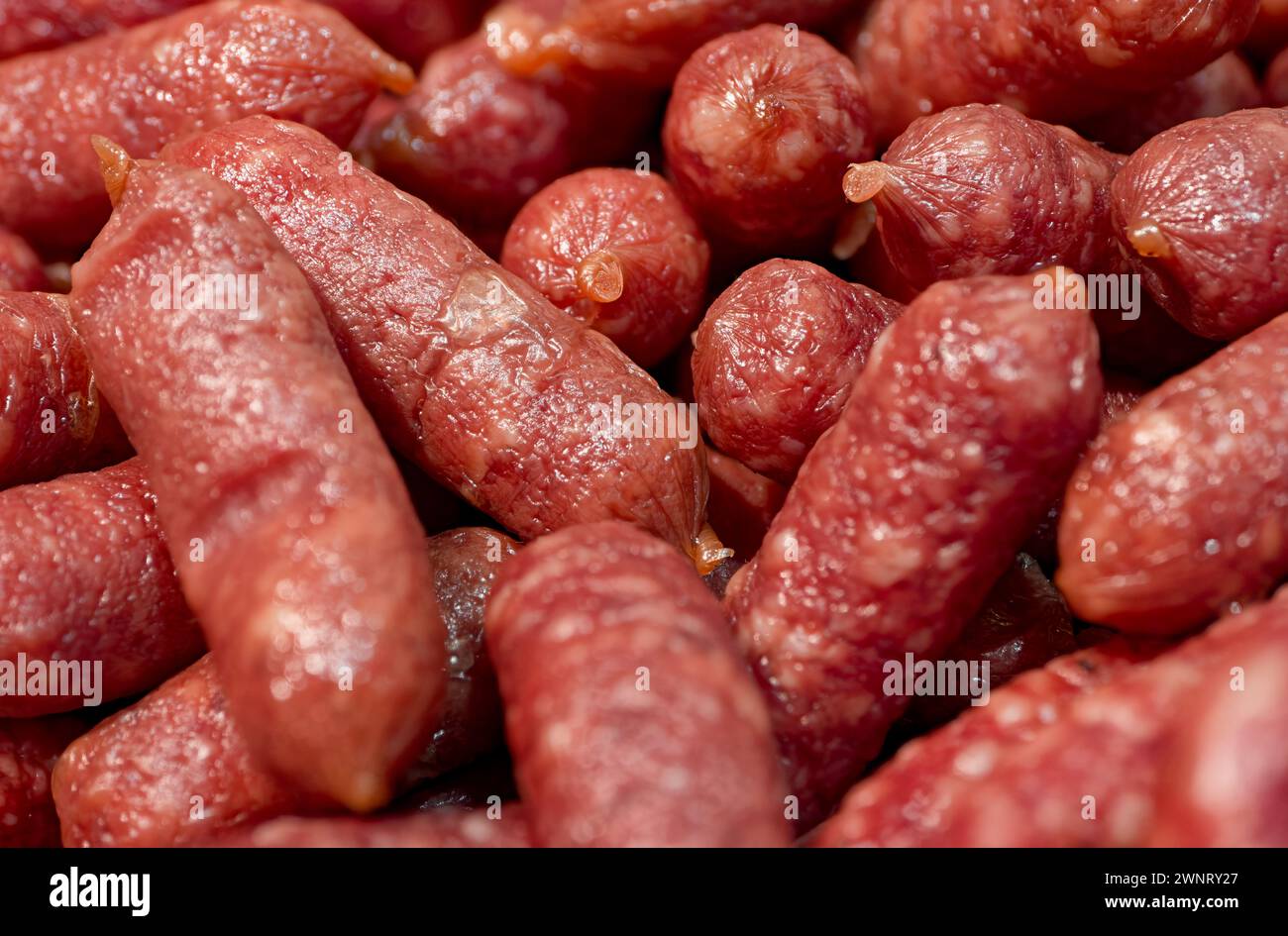 Smoked sausages on a meat market counter, close-up shot, abstract food background Stock Photo
