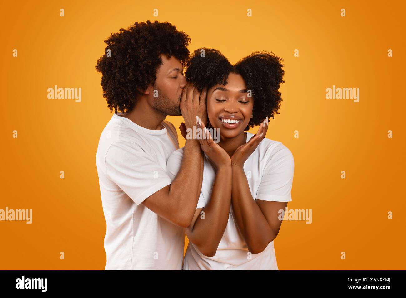 Black guy whispering something on his girlfriend ear Stock Photo