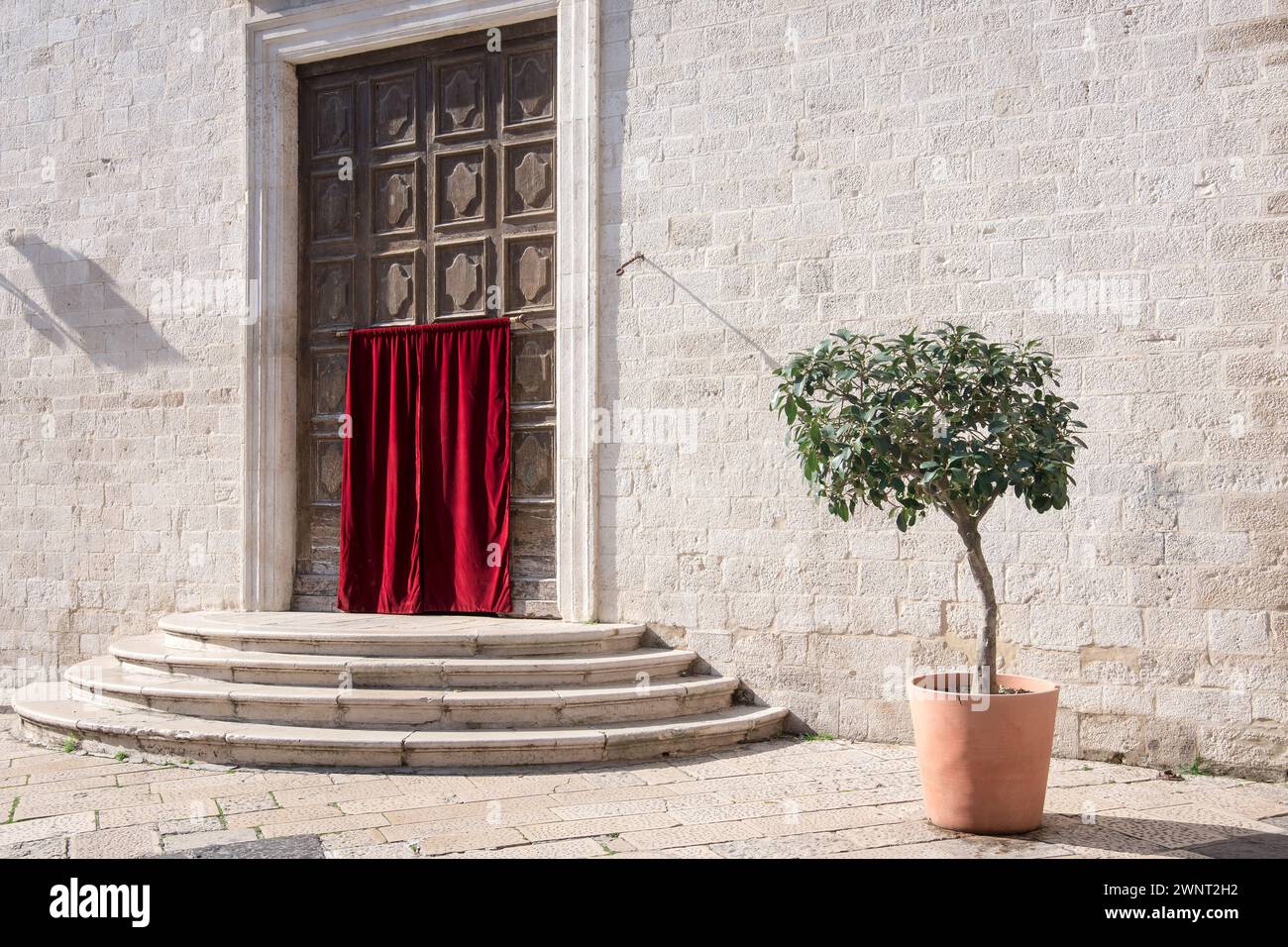 Entry covered with red velvet curtain in the Catholic church of Stock Photo