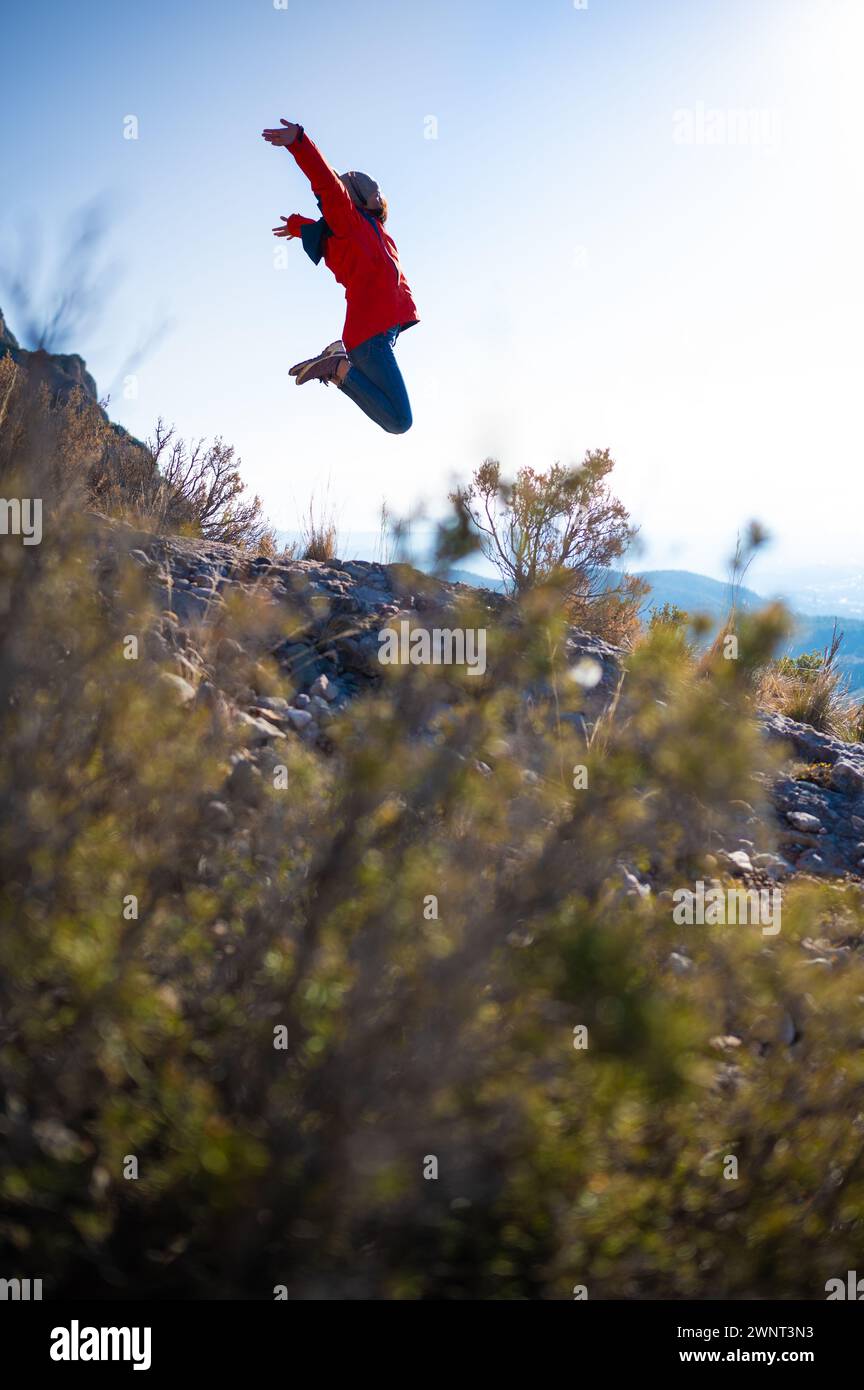 Girl jumping for joy in a mountainous environment. Stock Photo