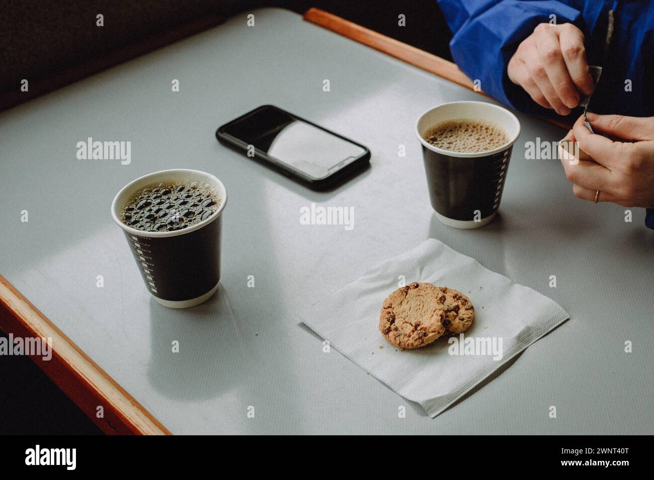 Coffee break at table with paper cups and cookies on napkin Stock Photo