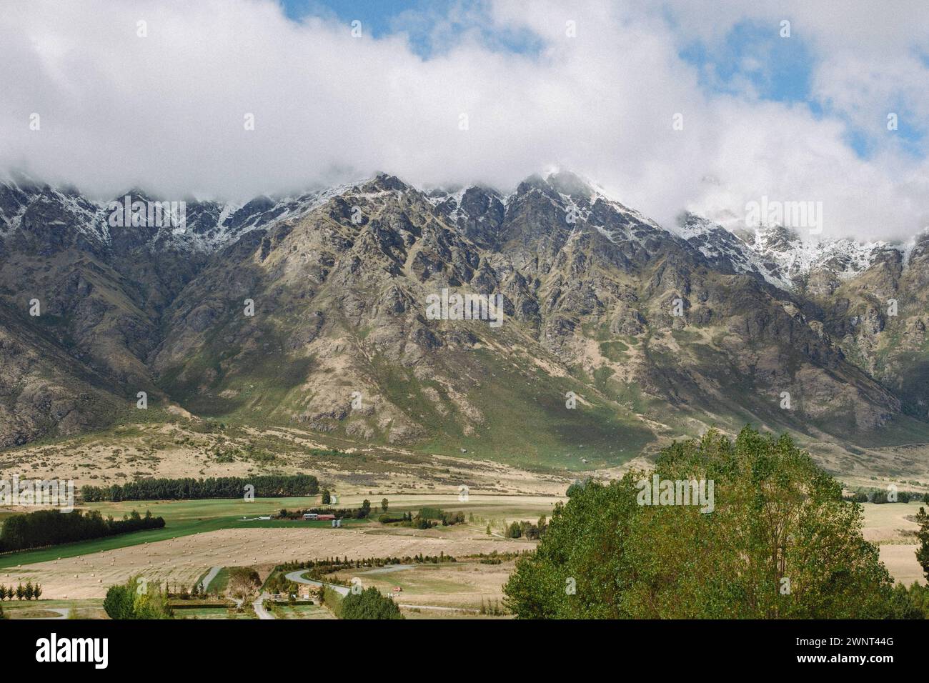 Ariel view of NZ town with snow capped textured mountain and sky Stock ...