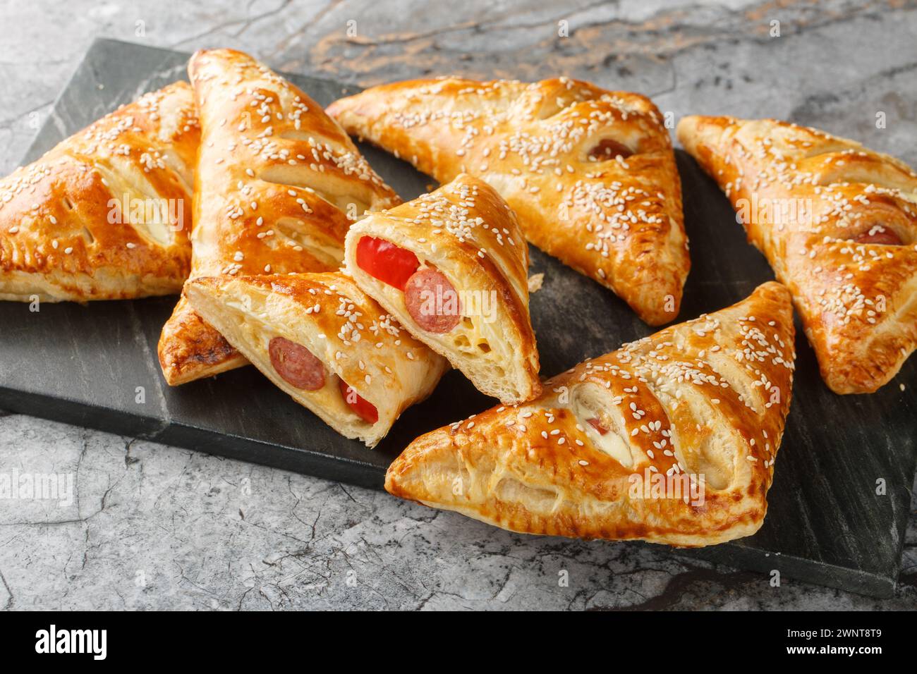 Puff pastry Pigs in a blanket pies with sausage, cheese, sesame and