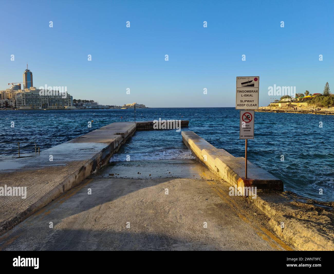 Exiles Bay, Sliema, Malta -March 15th 2021: Jetty and slipway with view of St Julian’s Bay in between San Giljan and Sliema. Stock Photo