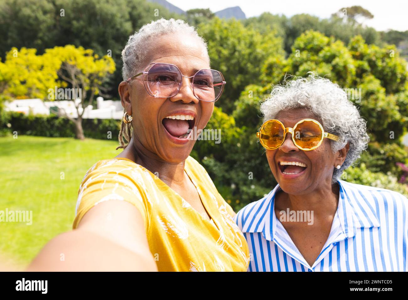 Senior African American woman and senior biracial woman share a joyful moment outdoors Stock Photo