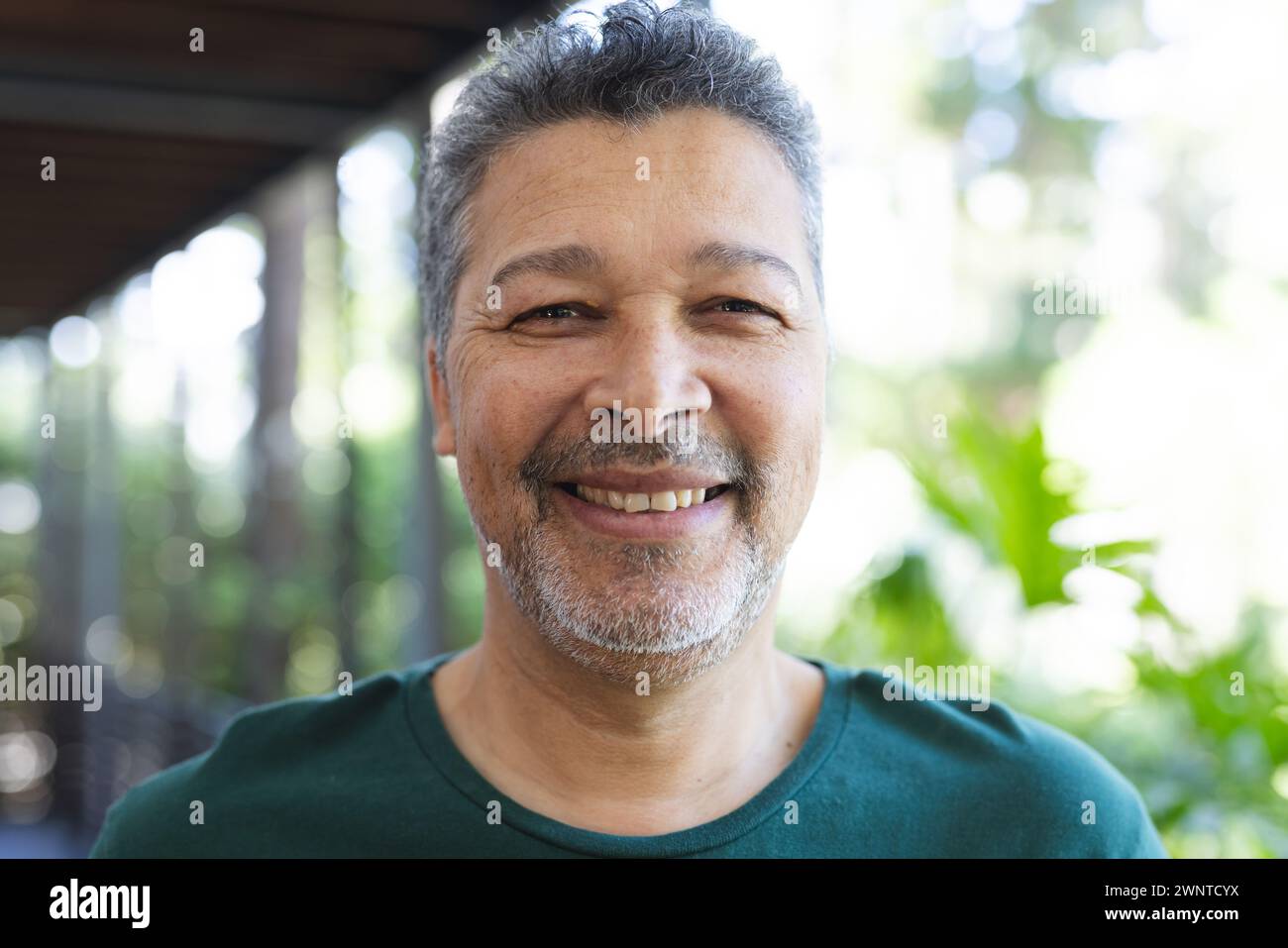 Senior biracial man with salt-and-pepper hair smiles warmly Stock Photo