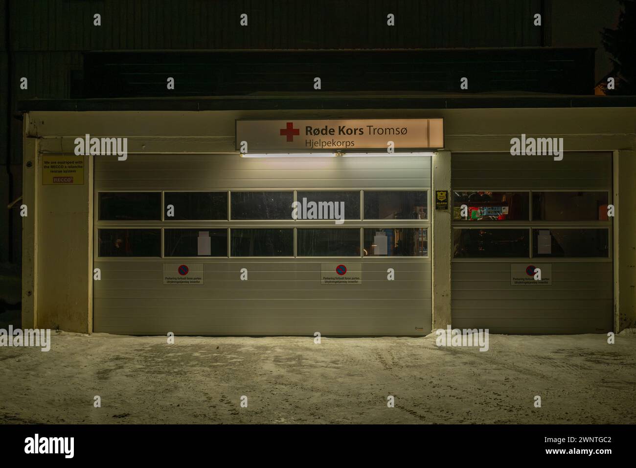 Doors of Tromso Red Cross centre, Rode Kors, taken at night with a light covering of snow on the drive Stock Photo