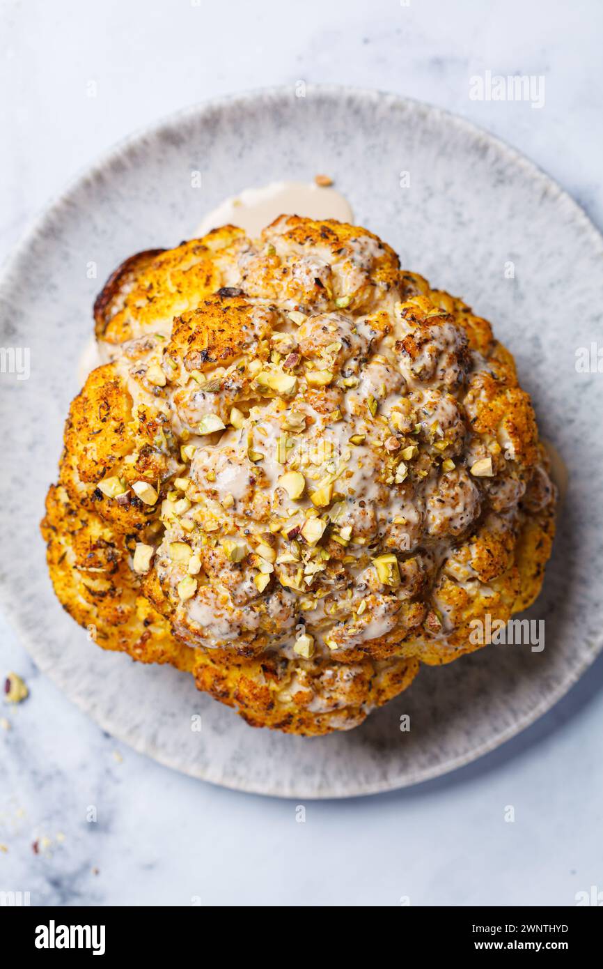 Spicy baked cauliflower with tahini dressing and pistachios, top view ...