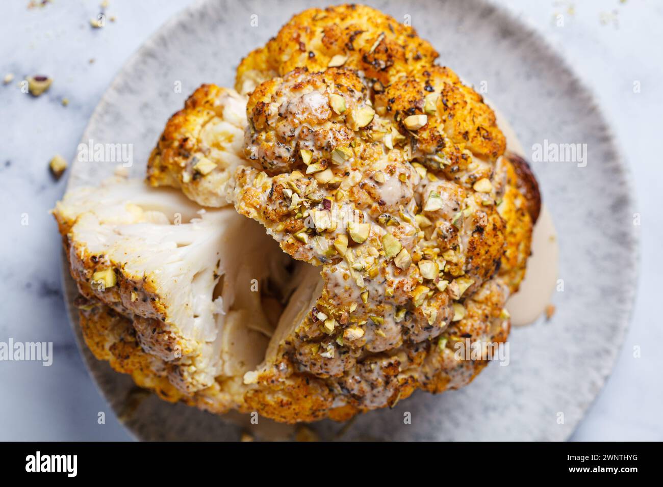 Spicy baked cauliflower with tahini dressing and pistachios, top view ...