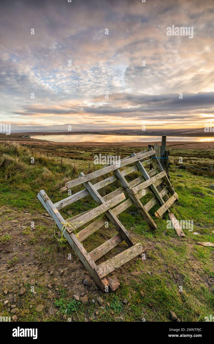 a broken wooden fence on the moors in yorkshire overlooking a reservoir. Stock Photo