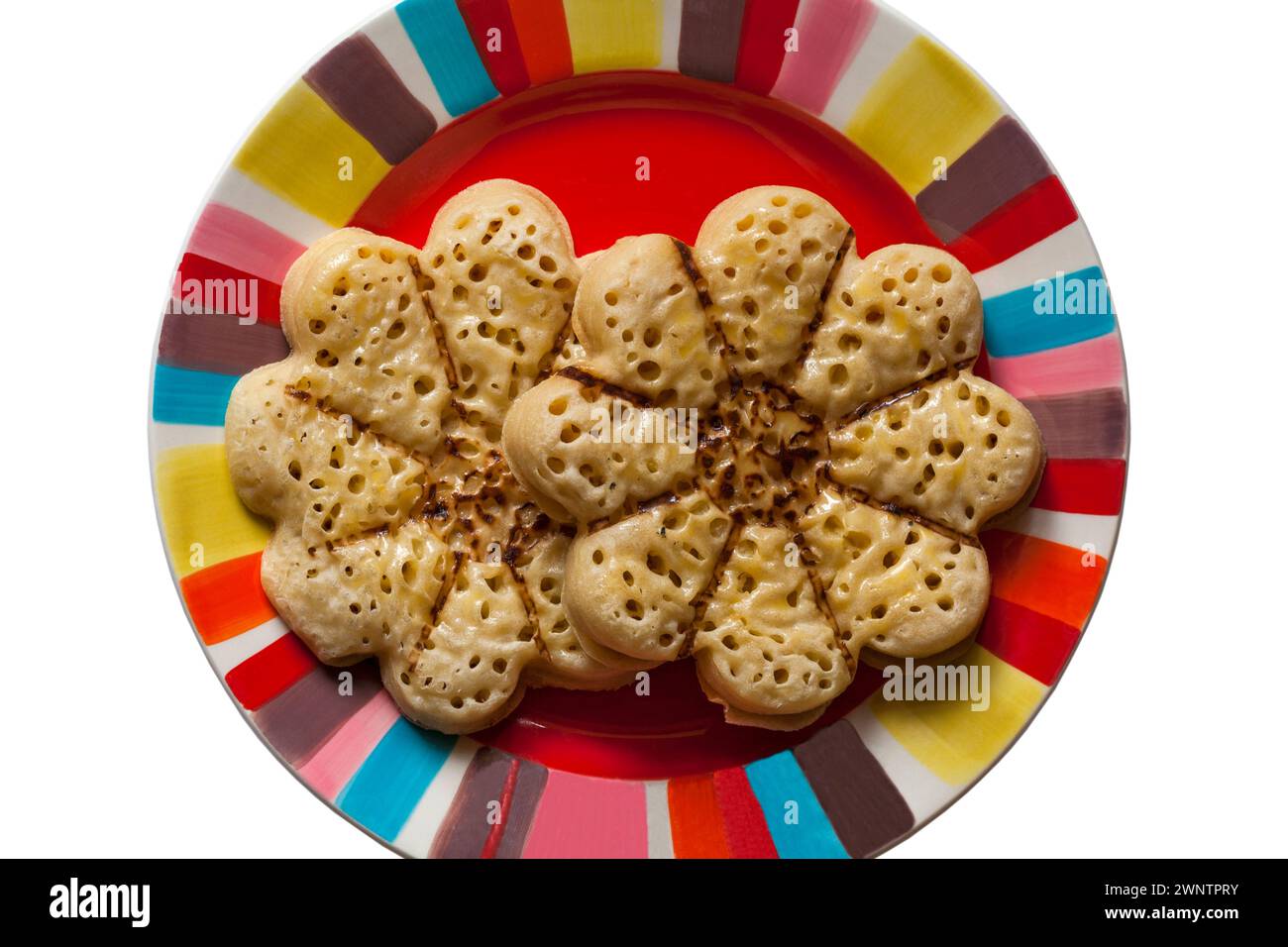 Blooming Lovely Crumpet light fluffy flower shaped crumpet from M&S  on colourful plate, looking down on from above Stock Photo
