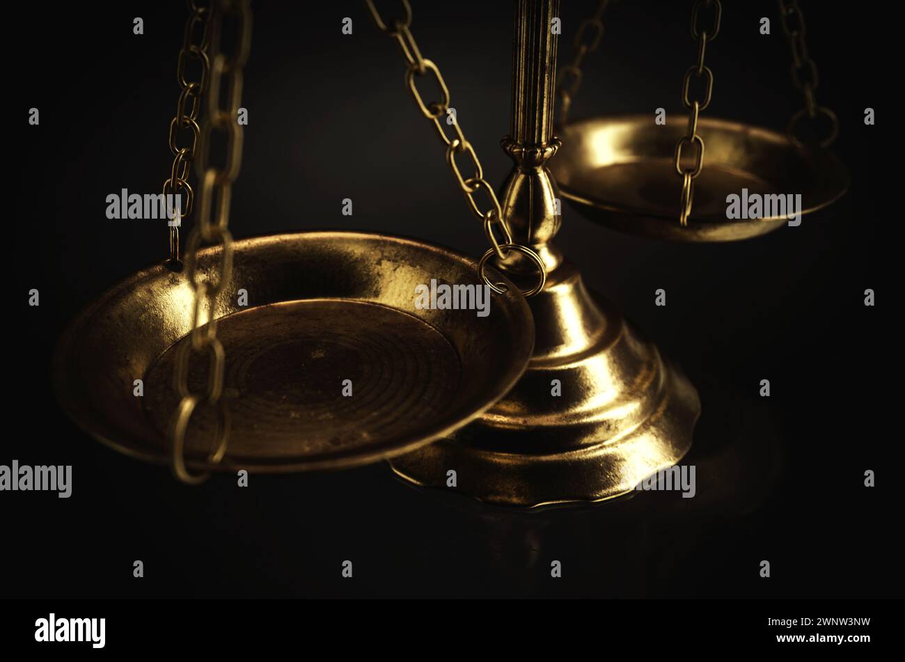 Ornate brass justice scales on a dark isolated background - 3D render Stock Photo