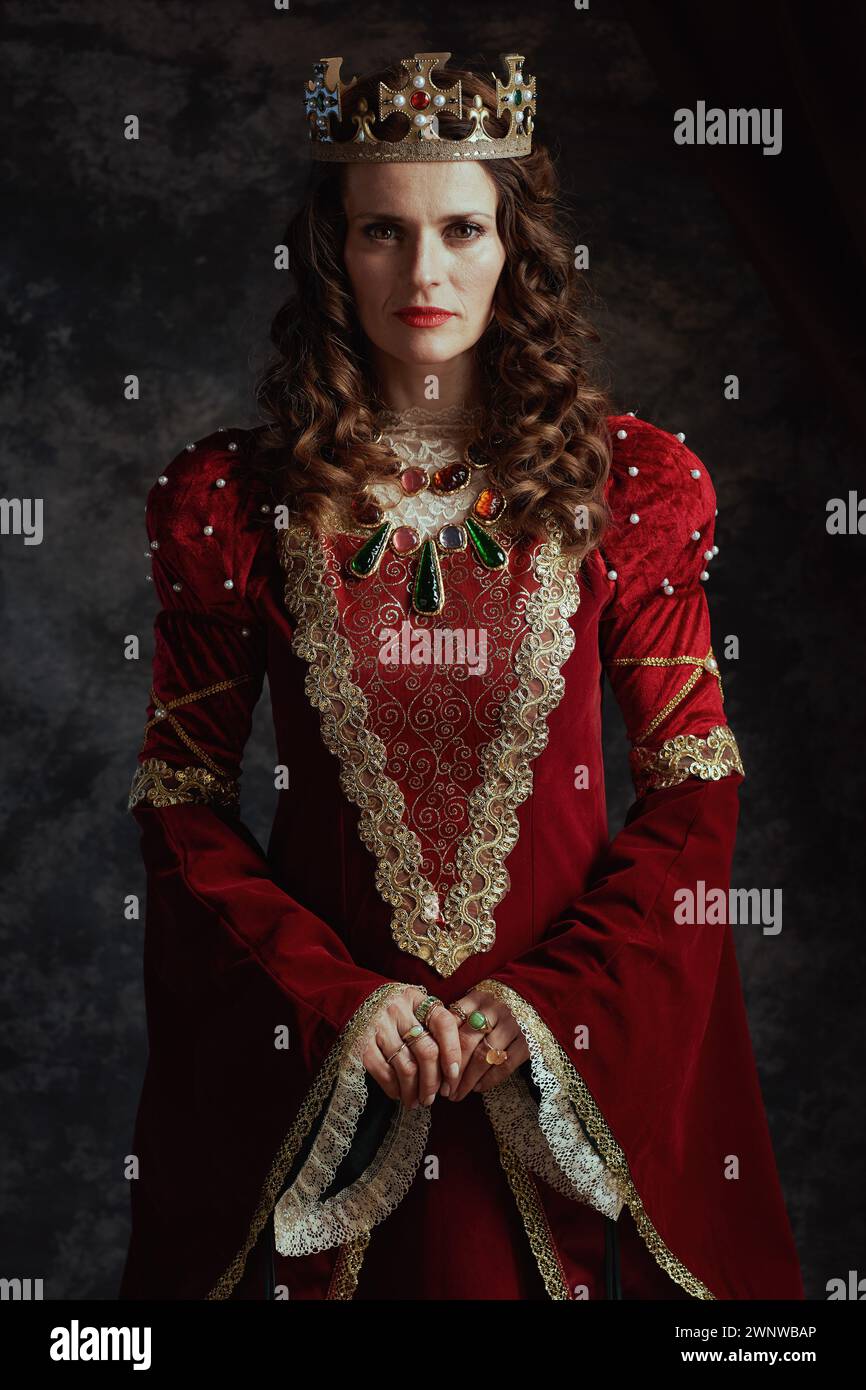 medieval queen in red dress with crown on dark gray background Stock ...