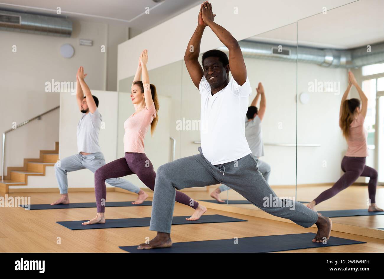African american standing in Ashta Chandrasana with hands in prayer above head Stock Photo