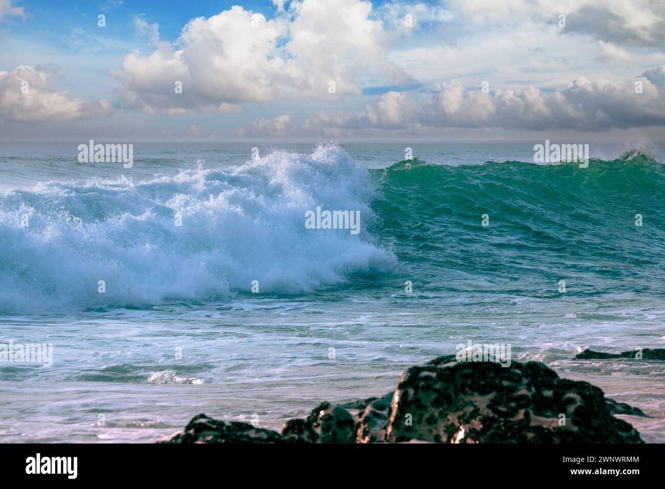 The wave rolls over the rocky shore Stock Photo - Alamy