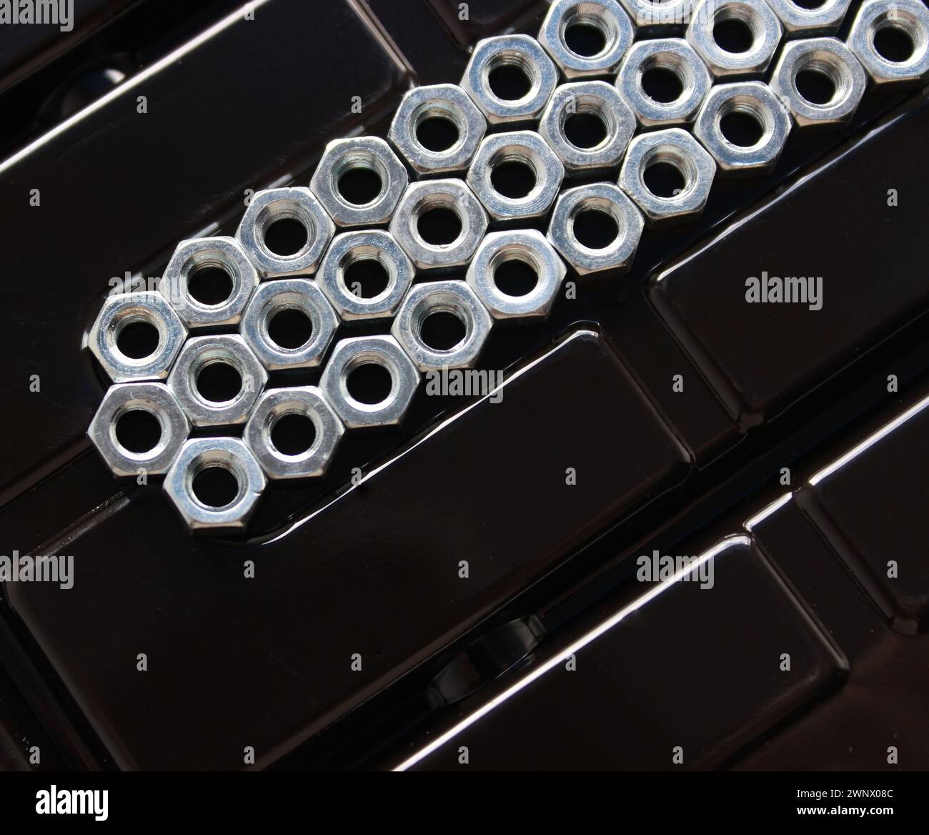 A compartment filled with iron nuts of the same diameter Stock Photo