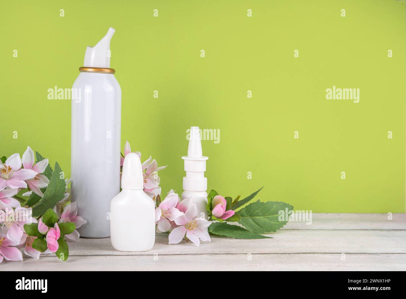 Seasonal spring allergies concept. Fresh spring blooming tree branches, various nasal allergy treatment, drops, spray bottles for allergies, rhinitis, Stock Photo