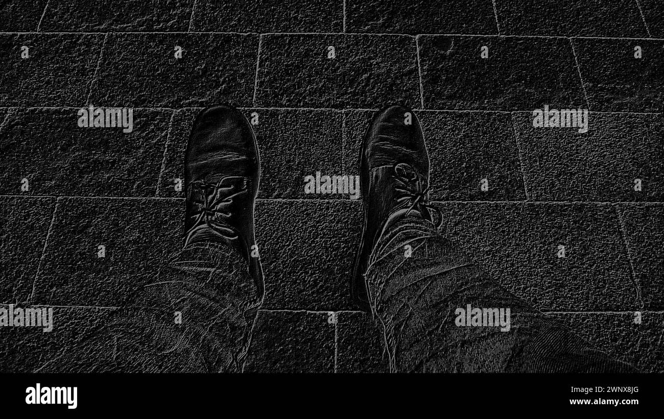 Monochrome black and white image. Feet in boots against the background