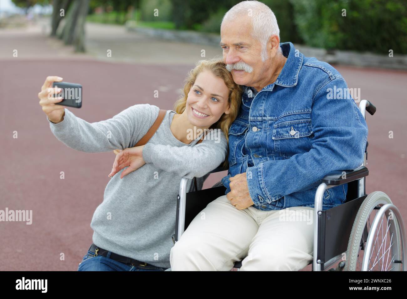 daughter and dad sitting in his wheelchair taking selfie Stock Photo ...