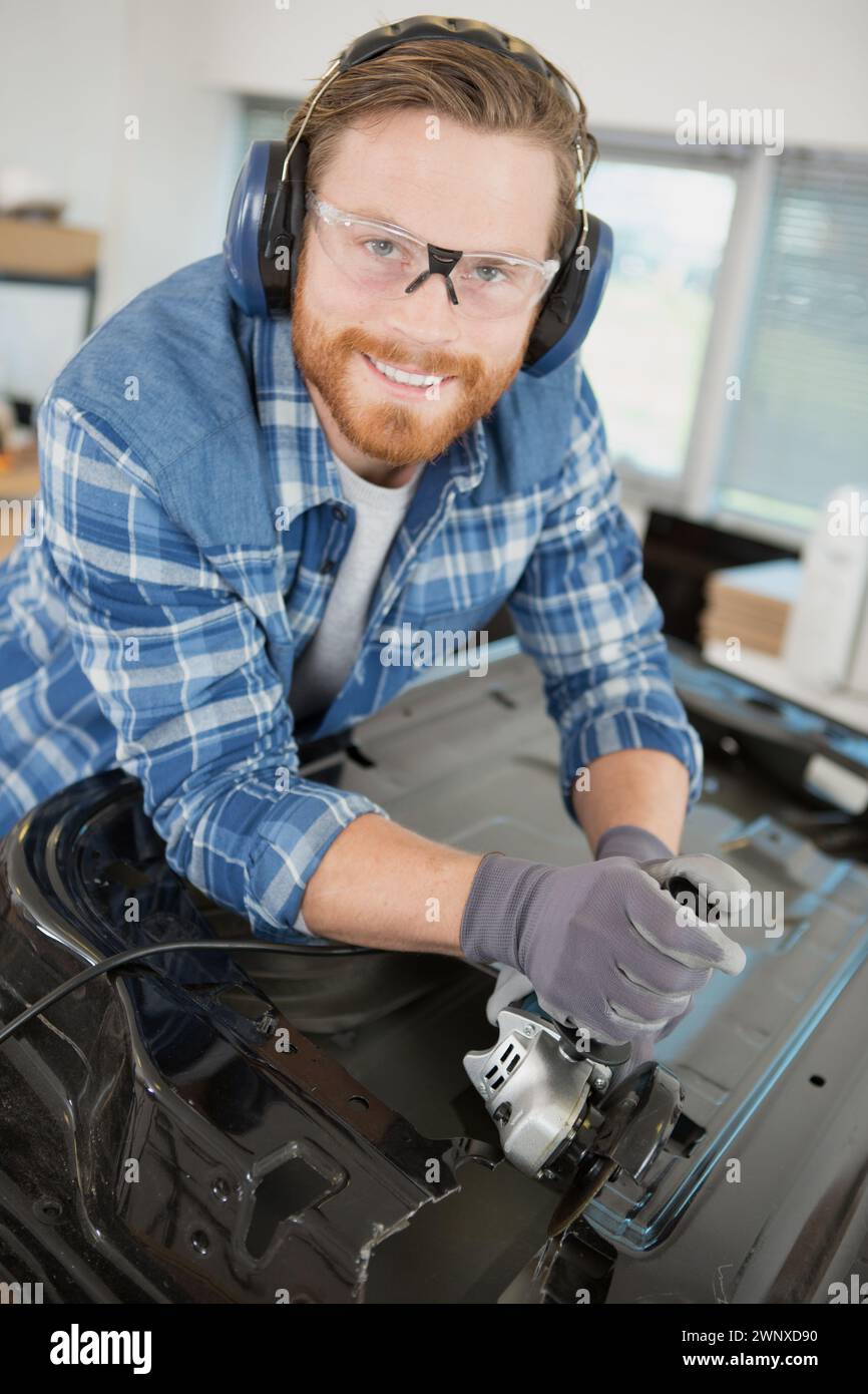 happy man checks the polishing with a torch Stock Photo