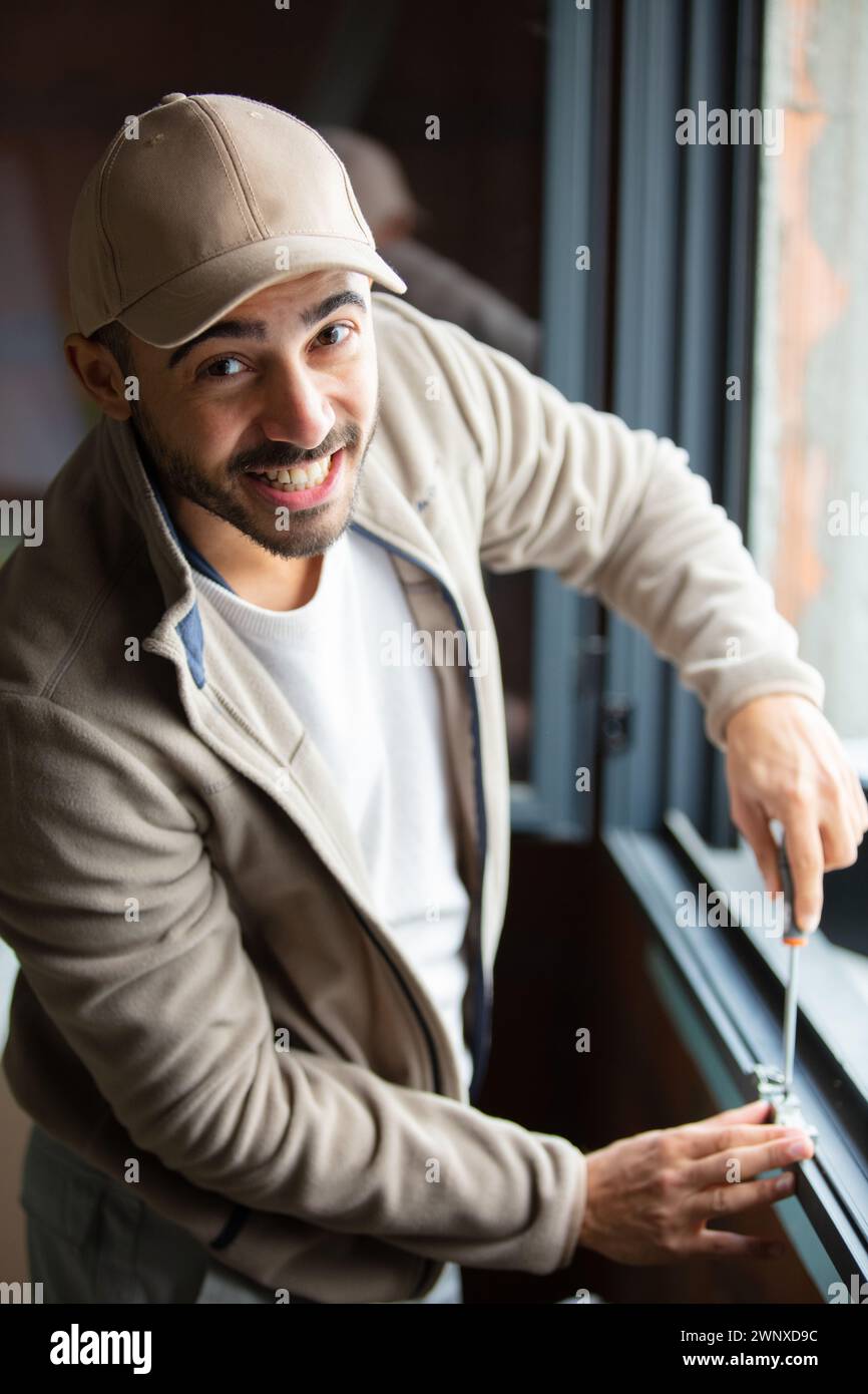 man installing roller shutter on window Stock Photo