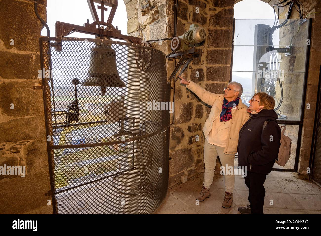 Tourists looking at the bells of the bell tower of Santa Maria of Puigcerdà (Cerdanya, Girona, Catalonia, Spain, Pyrenees) Stock Photo