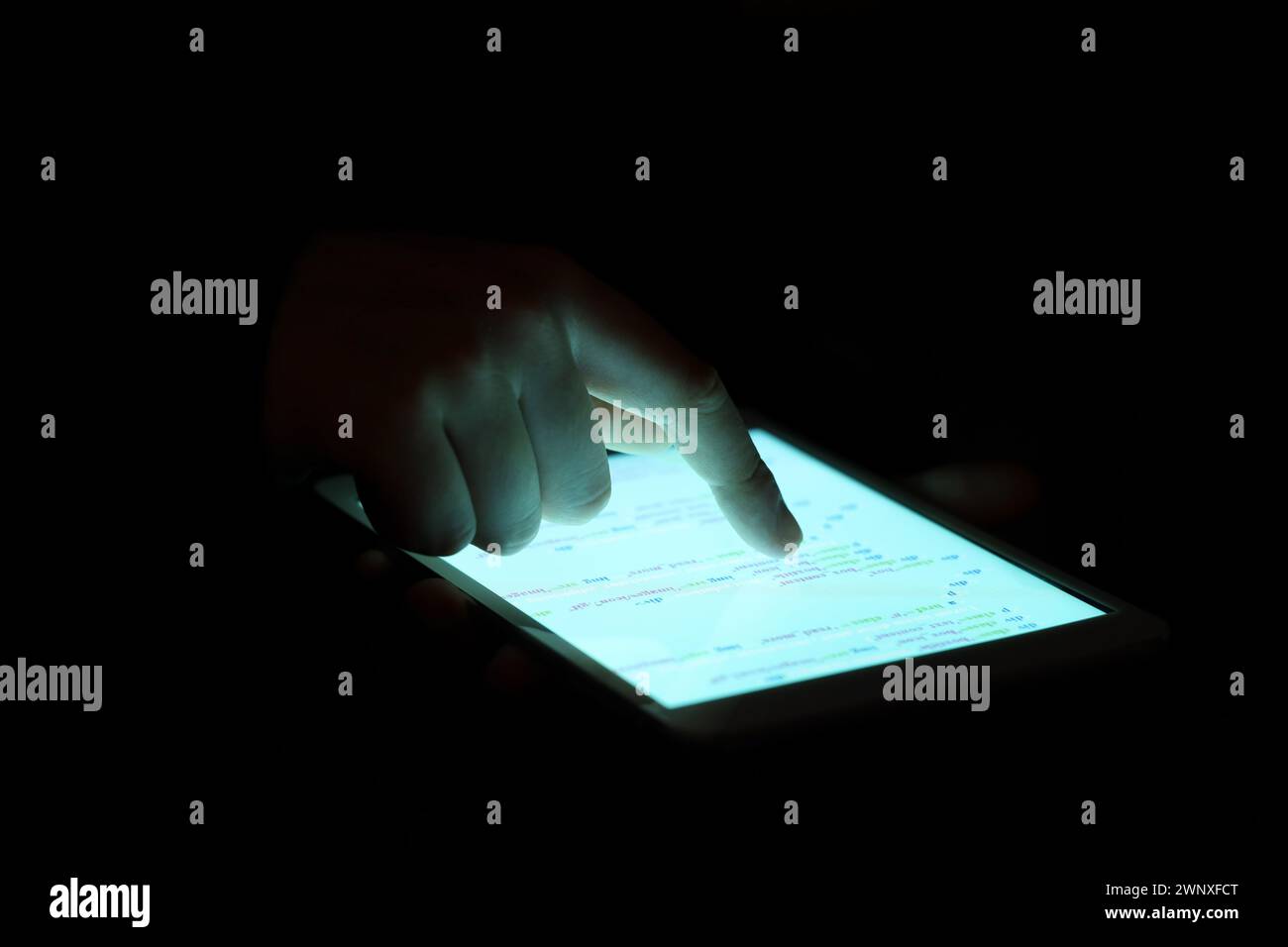 Hacker using tablet computer in dark room, closeup Stock Photo