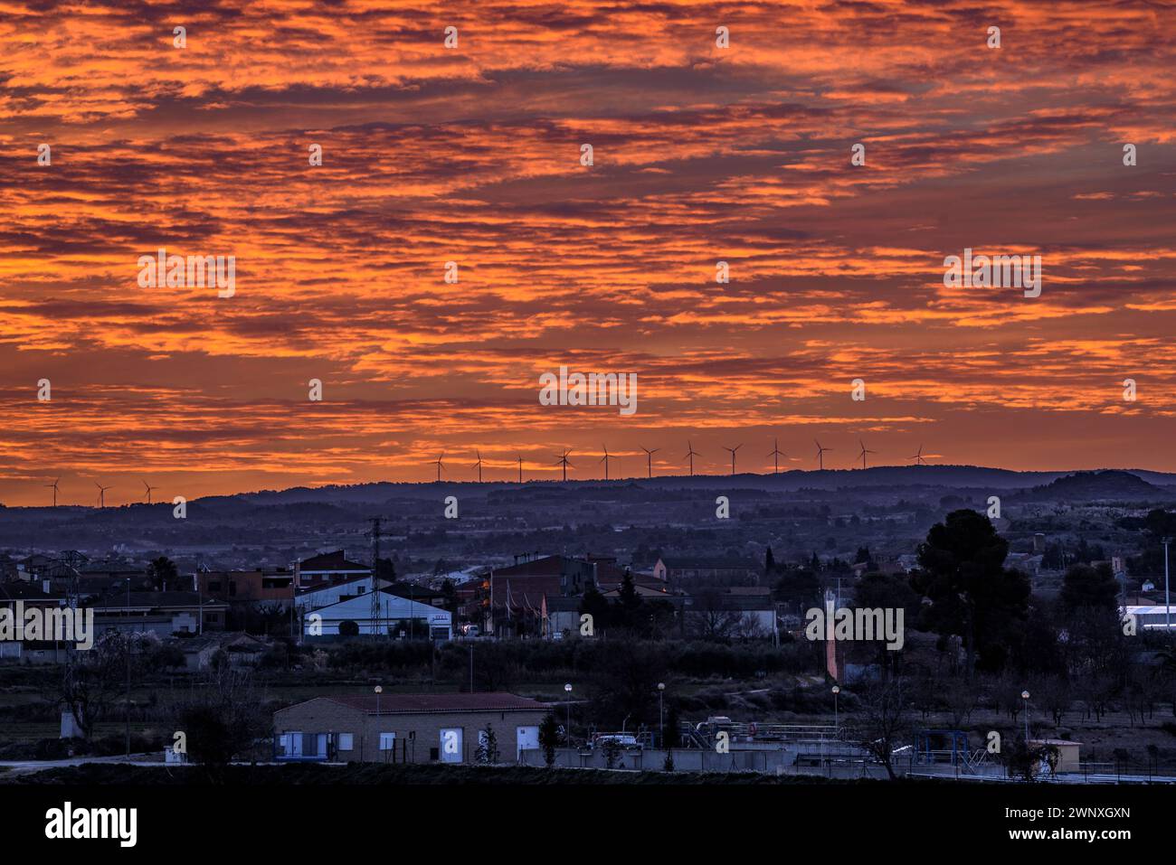 Red sky over the town of Arbeca in spring with flowering almond trees (Les Garrigues, Lleida, Catalonia, Spain) ESP: Cielo rojizo sobre Arbeca, Lérida Stock Photo