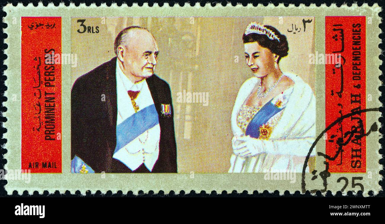 SHARJAH - CIRCA 1972: A stamp printed in United Arab Emirates shows Winston Churchill and Queen Elizabeth II of England Stock Photo