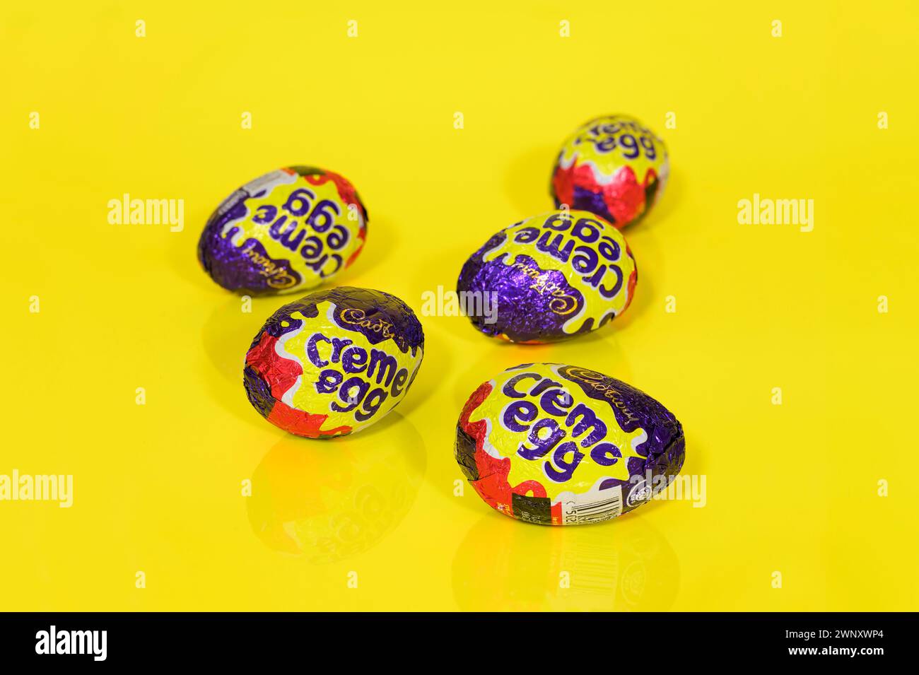 Five Cadbury Creme Eggs on Yellow Background, Easter Eggs Stock Photo