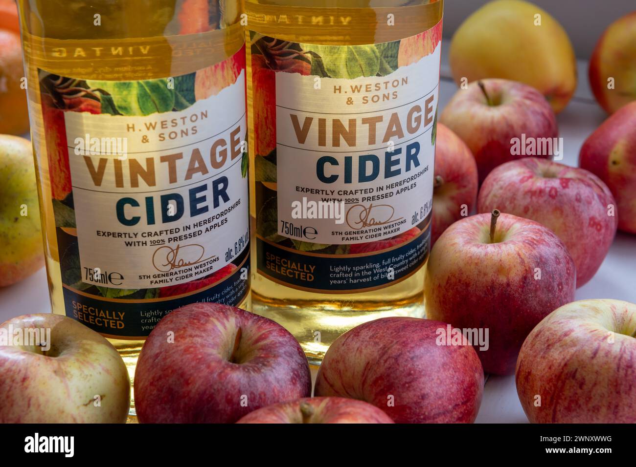 London. UK- 02.25.2024. Close up of bottles of vintage cider surrounded by apples. Stock Photo