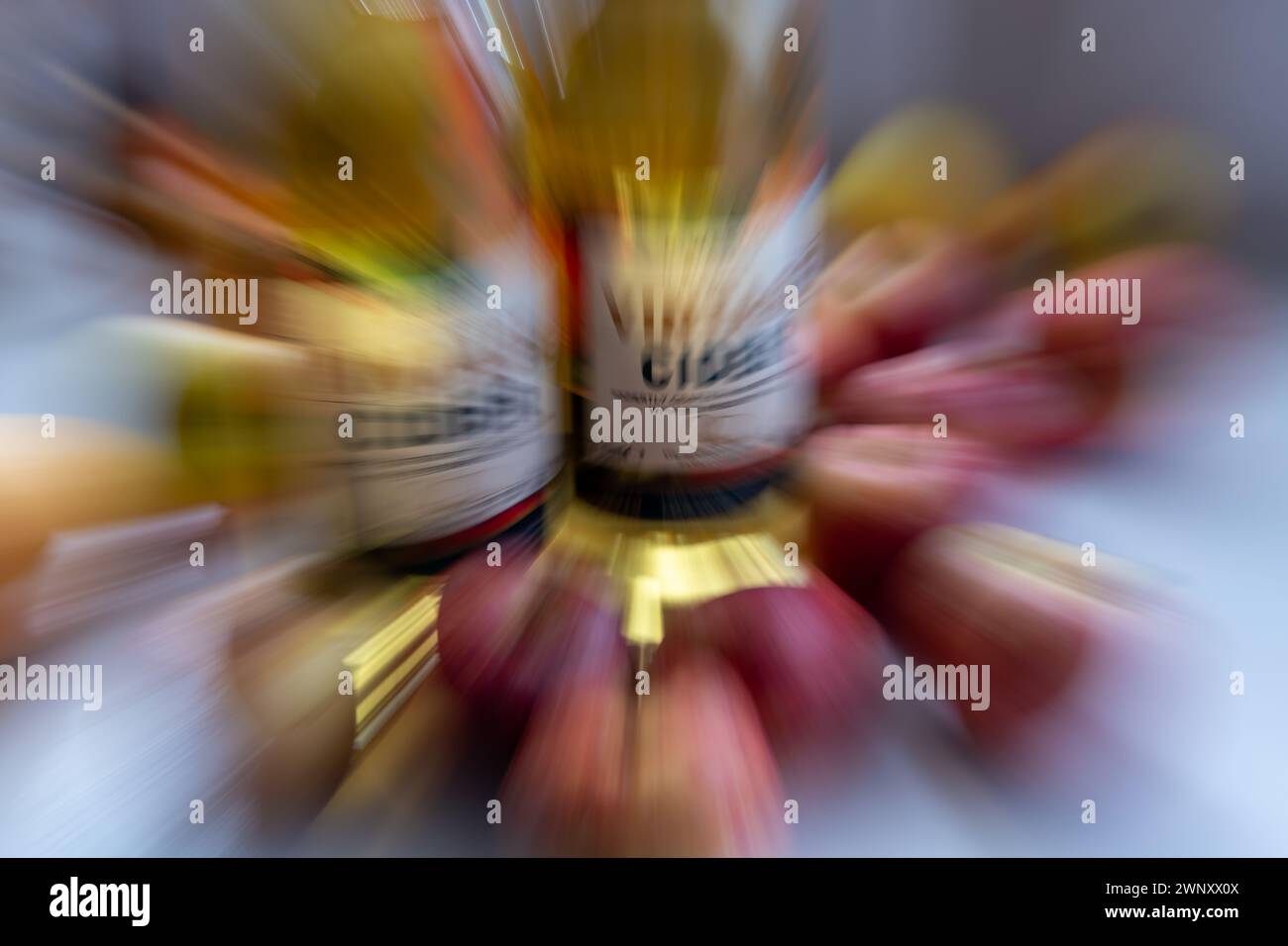 A zoom burst background of bottles of vintage cider surrounded by apples. Stock Photo