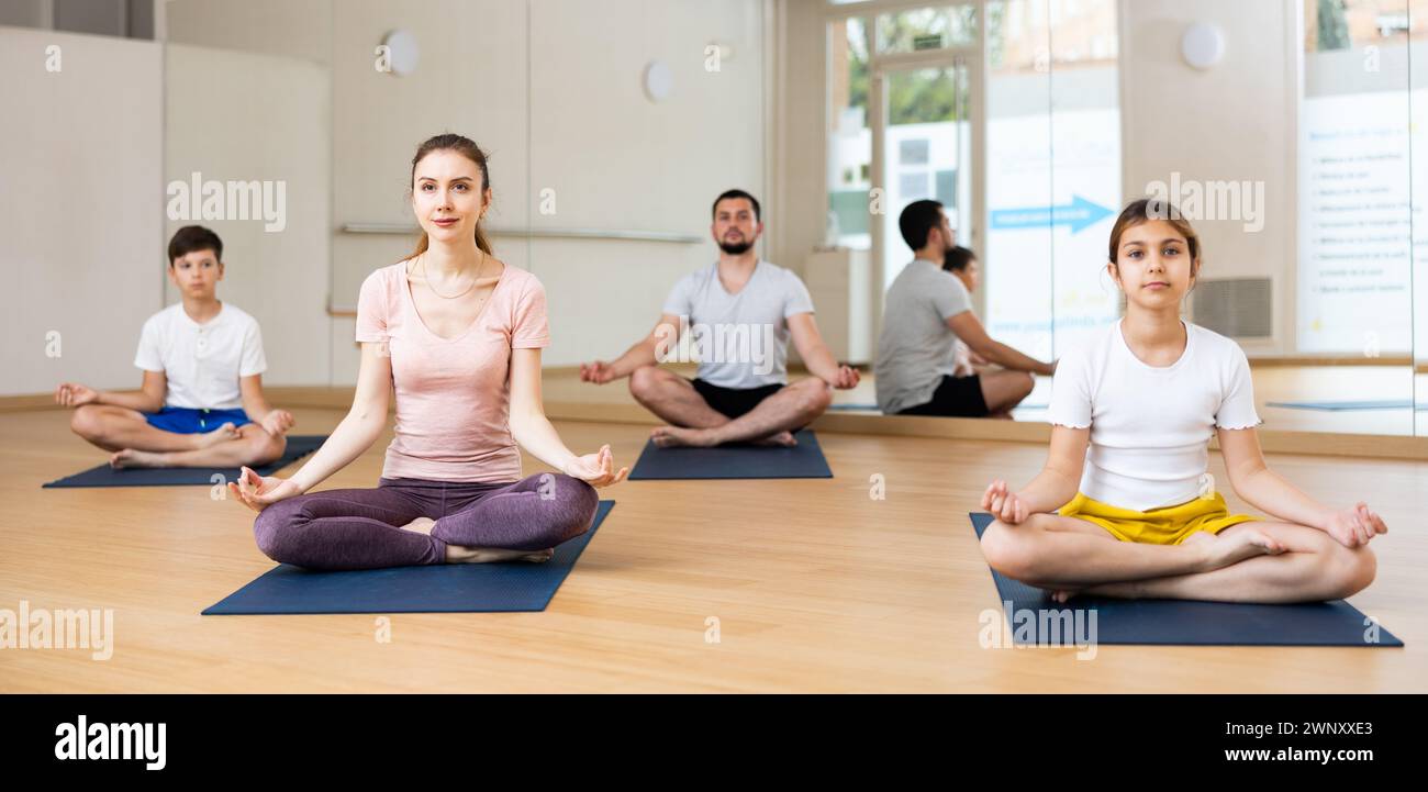 Family sitting in lotus pose in gym Stock Photo - Alamy