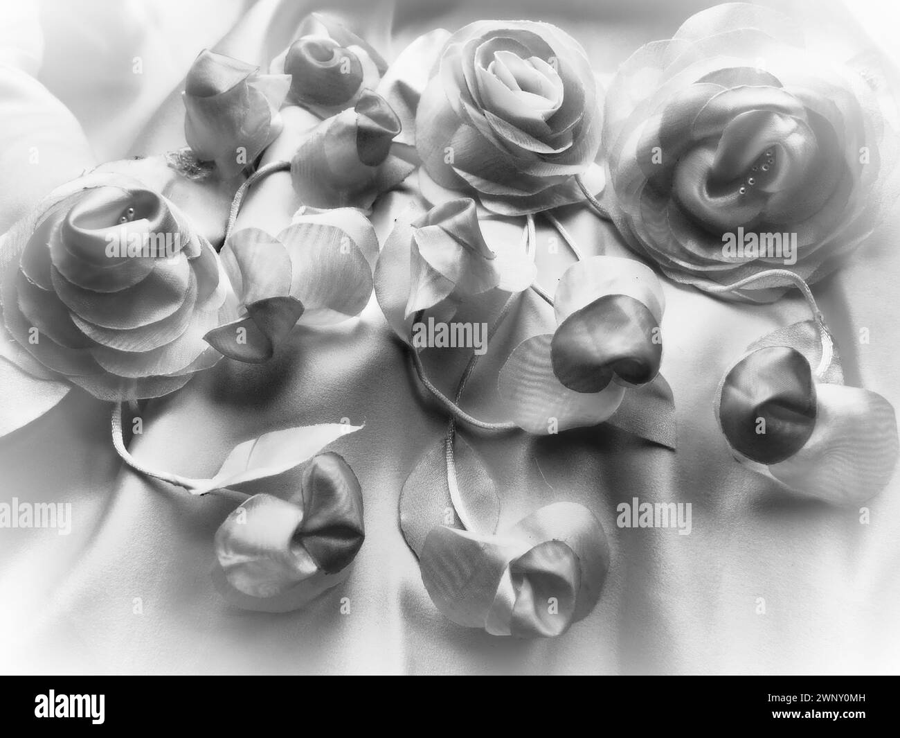 Wedding flowers made of fabric for the decoration of the bride's wedding dress. Vintage style, blurry foggy image. Several artificial flowers and buds Stock Photo