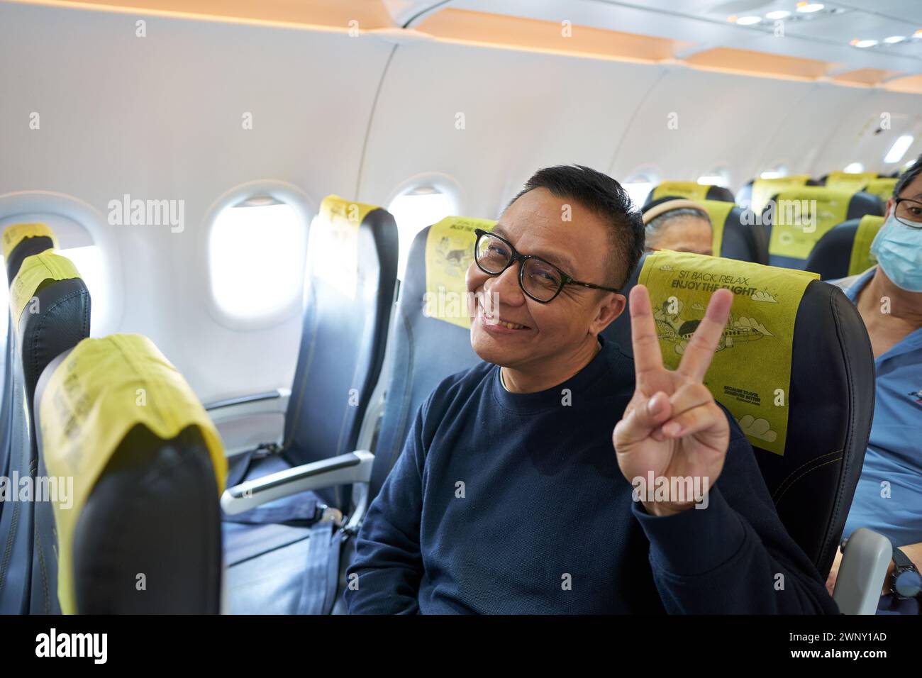 SINGAPORE - NOVEMBER 07, 2023: man posing in economy class at Scoot Airbus A321neo. Stock Photo