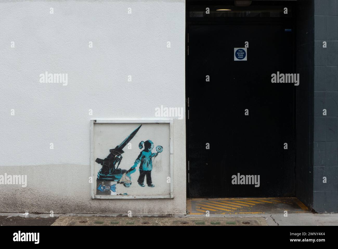 A grafitti of a girl and a rocket of world-famous street-artist Banksy on a wall in Camden Town, London. The artwork is listed in streetmaps and apps. Stock Photo