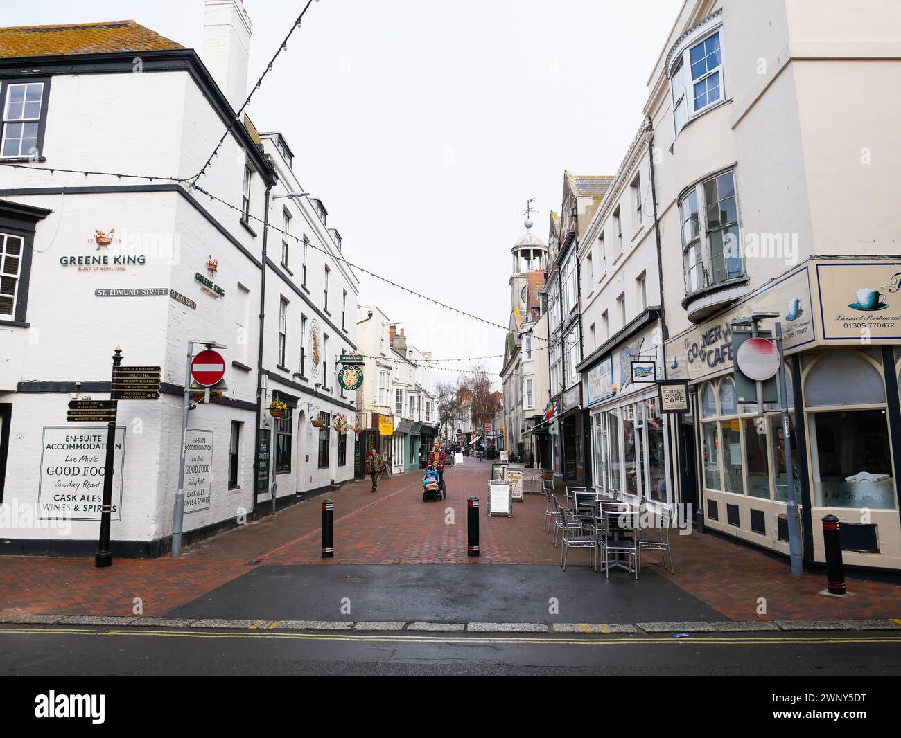 St. Mary Street in Weymouth old town with many shops and pedestrians walking in the street. Stock Photo