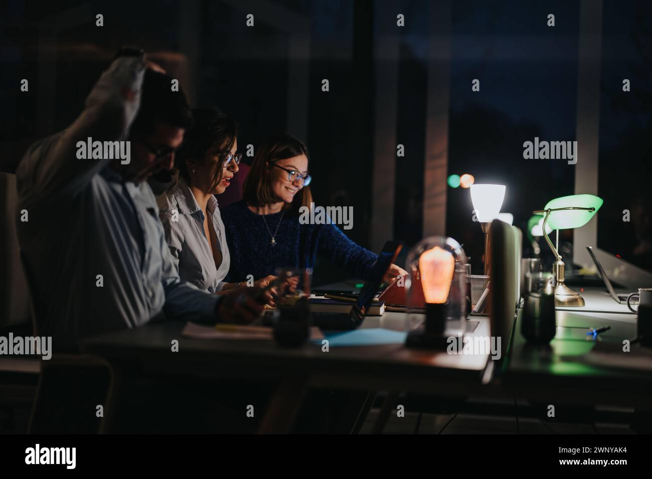 Diverse group of business colleagues focused on project work late at ...