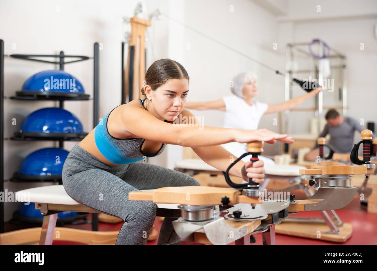 Young girl during Pilates training performs exercises and tasks on ...