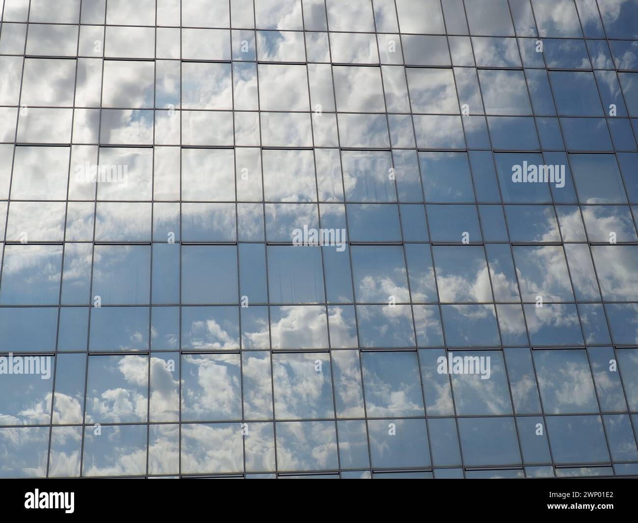 The sky and glass facade of the building. Reflection of the blue sky ...