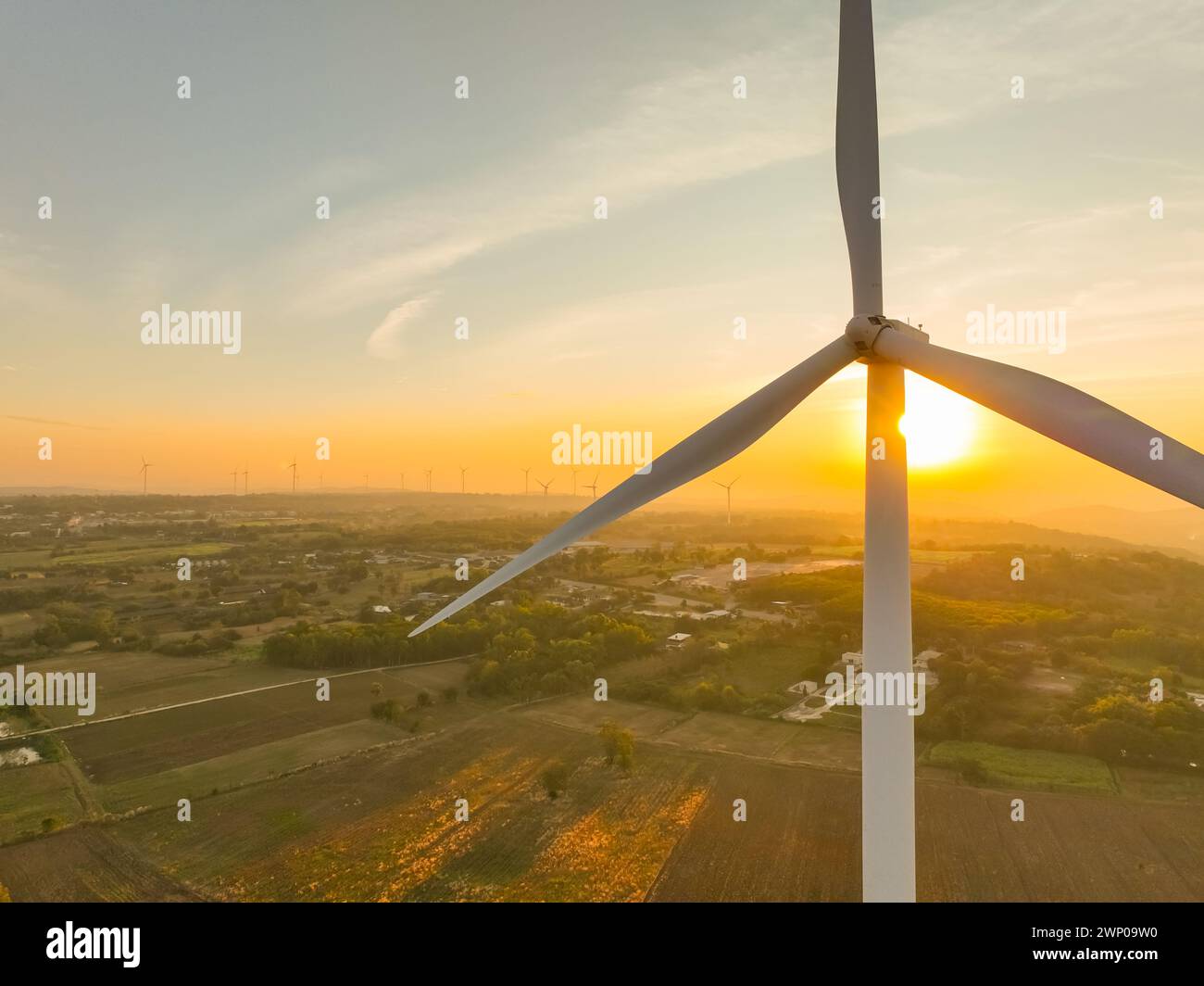 Wind farm field and sunset sky. Wind power. Sustainable, renewable energy. Wind turbines generate electricity. Sustainable development. Green tech Stock Photo