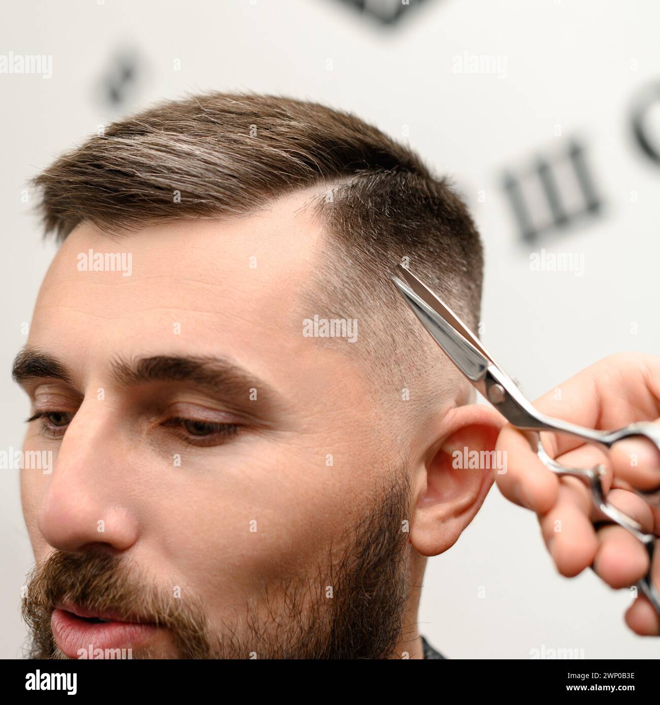 Haircut and alignment of the contour of the head with scissors. Short haircut in the barbershop. Stock Photo