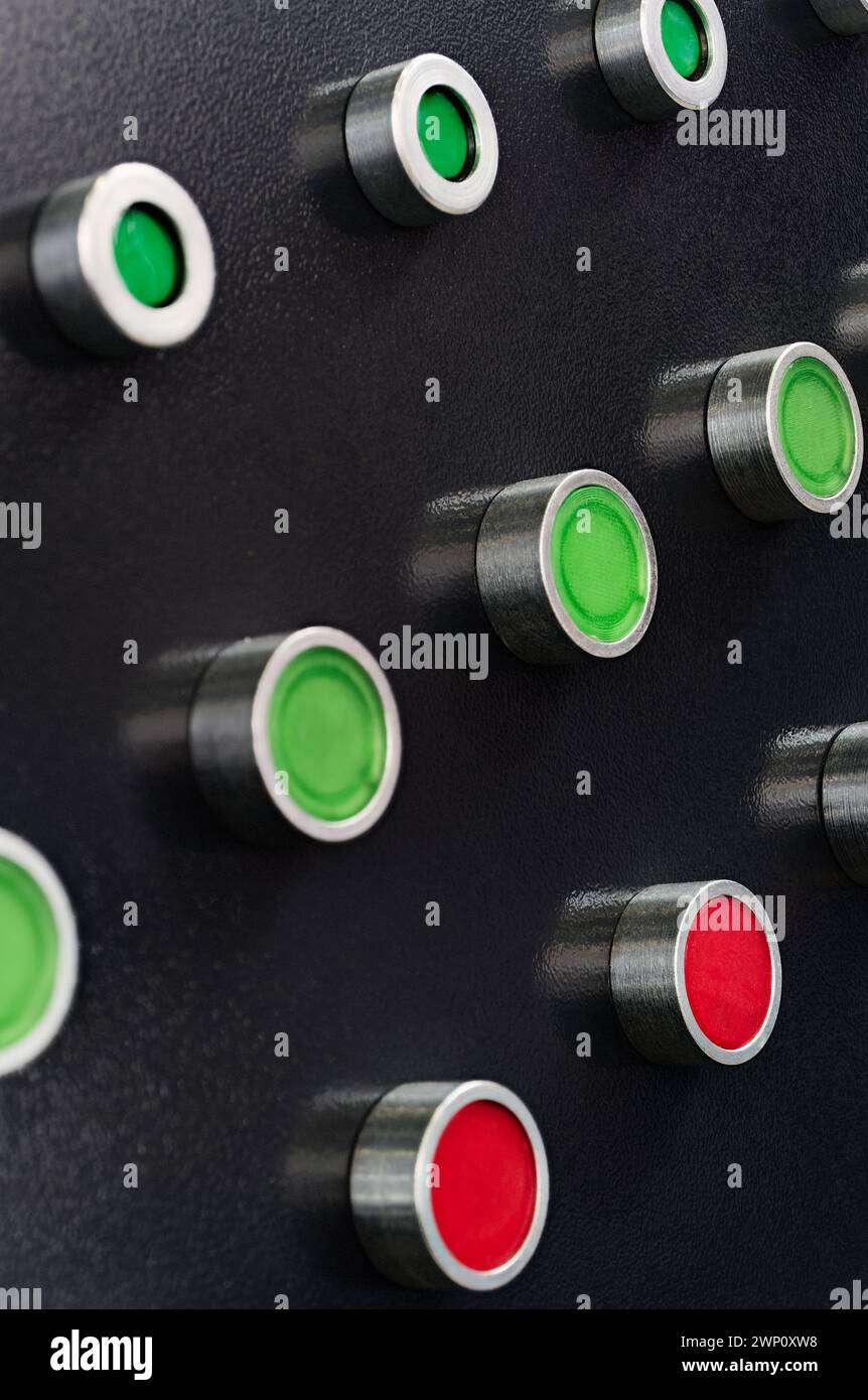 Black control panel with red and green round lamps and buttons. Abstract industrial background. Stock Photo